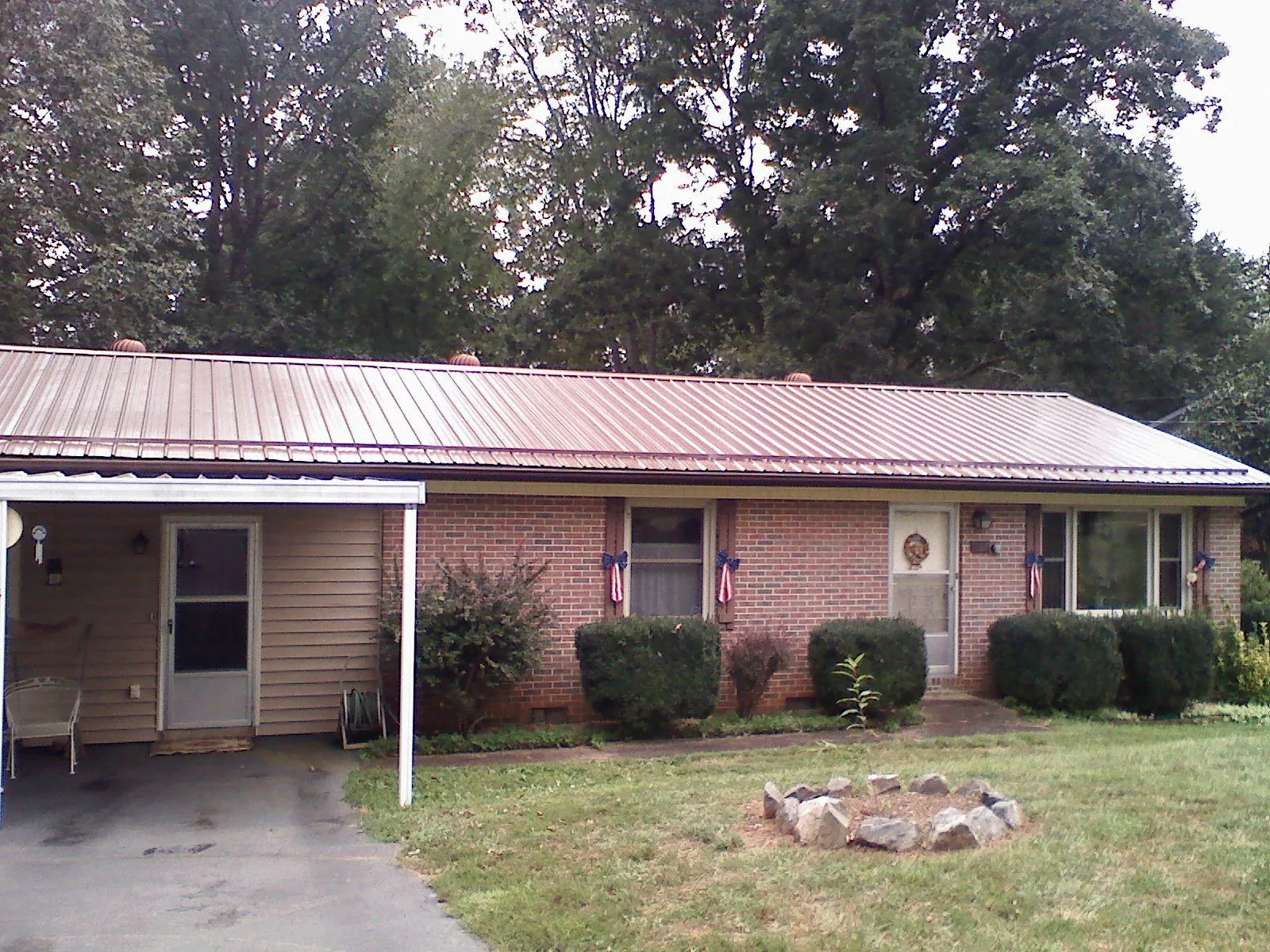 Bronze metal roof and carport on a brick ranch home — Roof Repair work by our crew in Warriors Mark